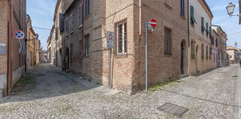 Una calle empedrada pasa entre edificios de ladrillo muy próximos.
