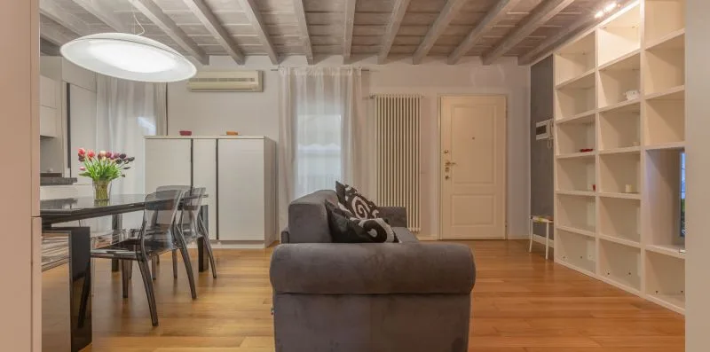 A living room with seating beside a dining table and open shelving.