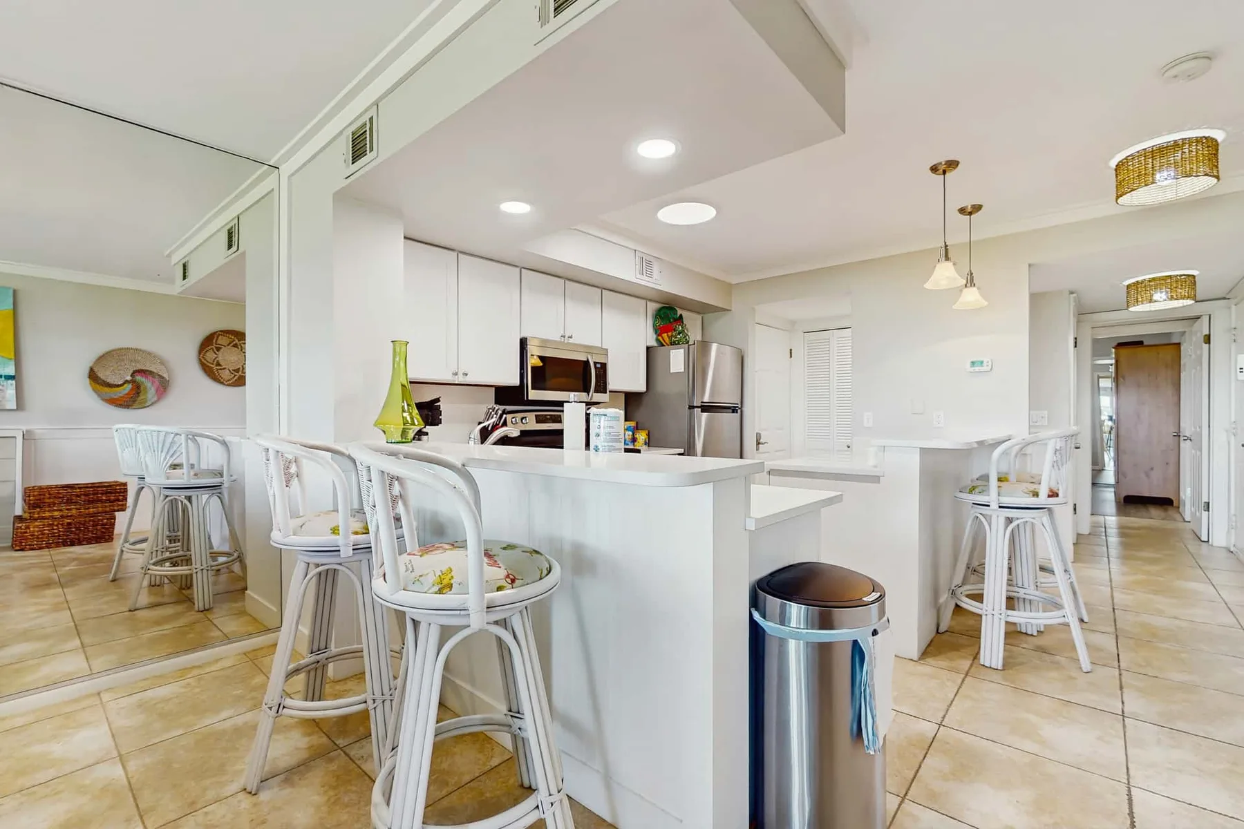 A bright kitchen with a central island and white bar seating.