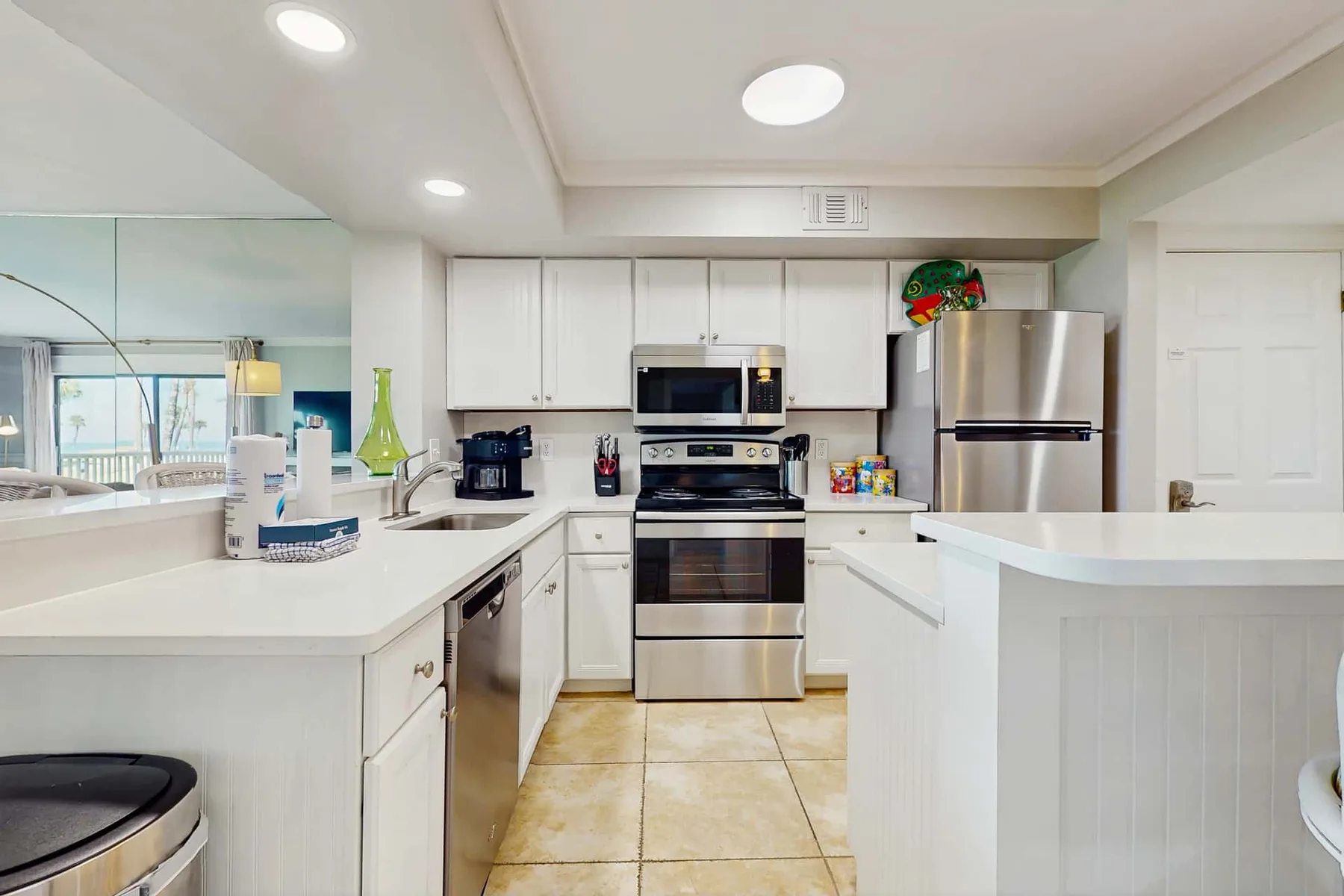 A bright kitchen with white cabinets and stainless steel appliances.