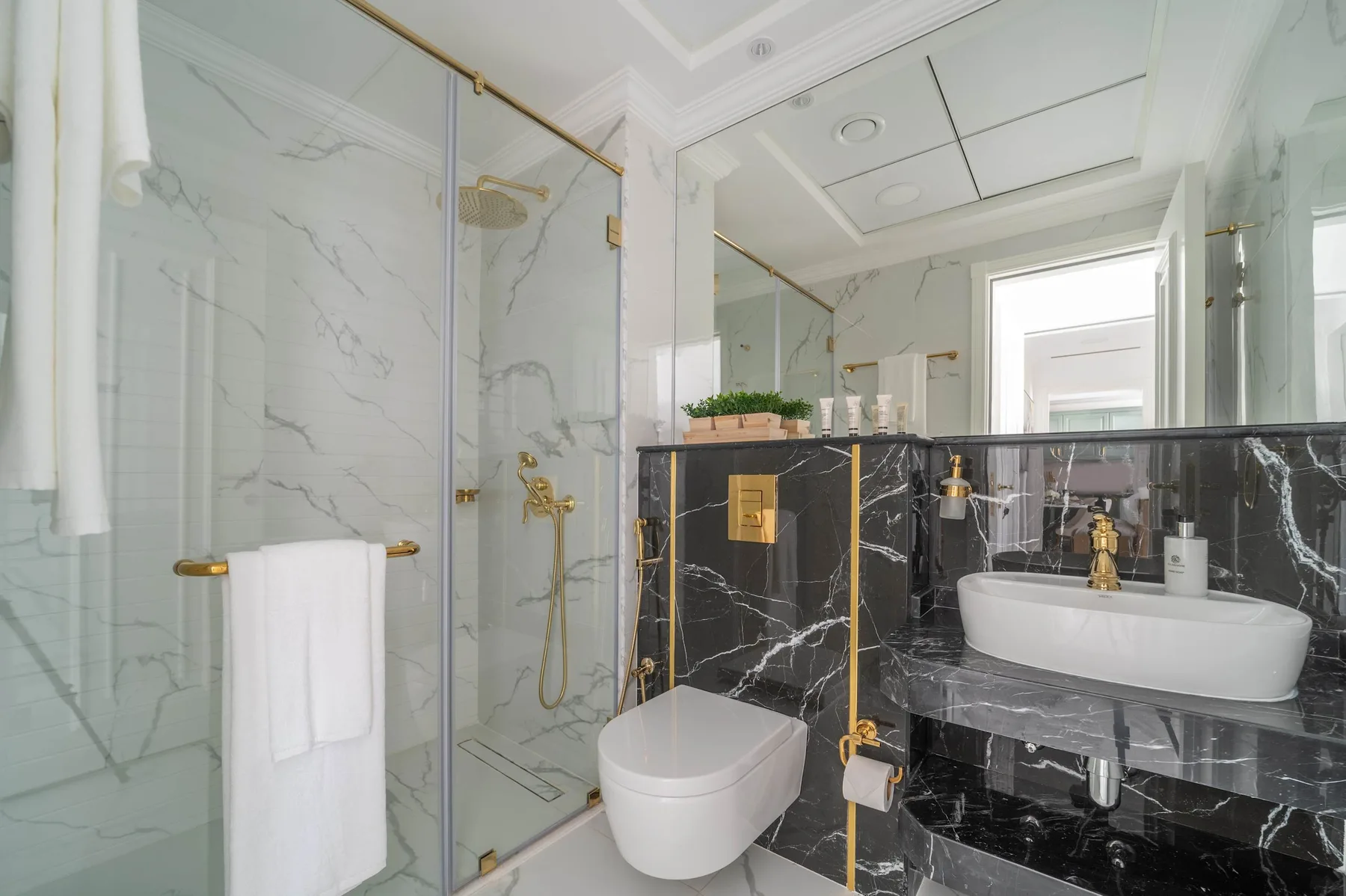 Un baño con ducha de vidrio, inodoro y lavabo sobre encimera.