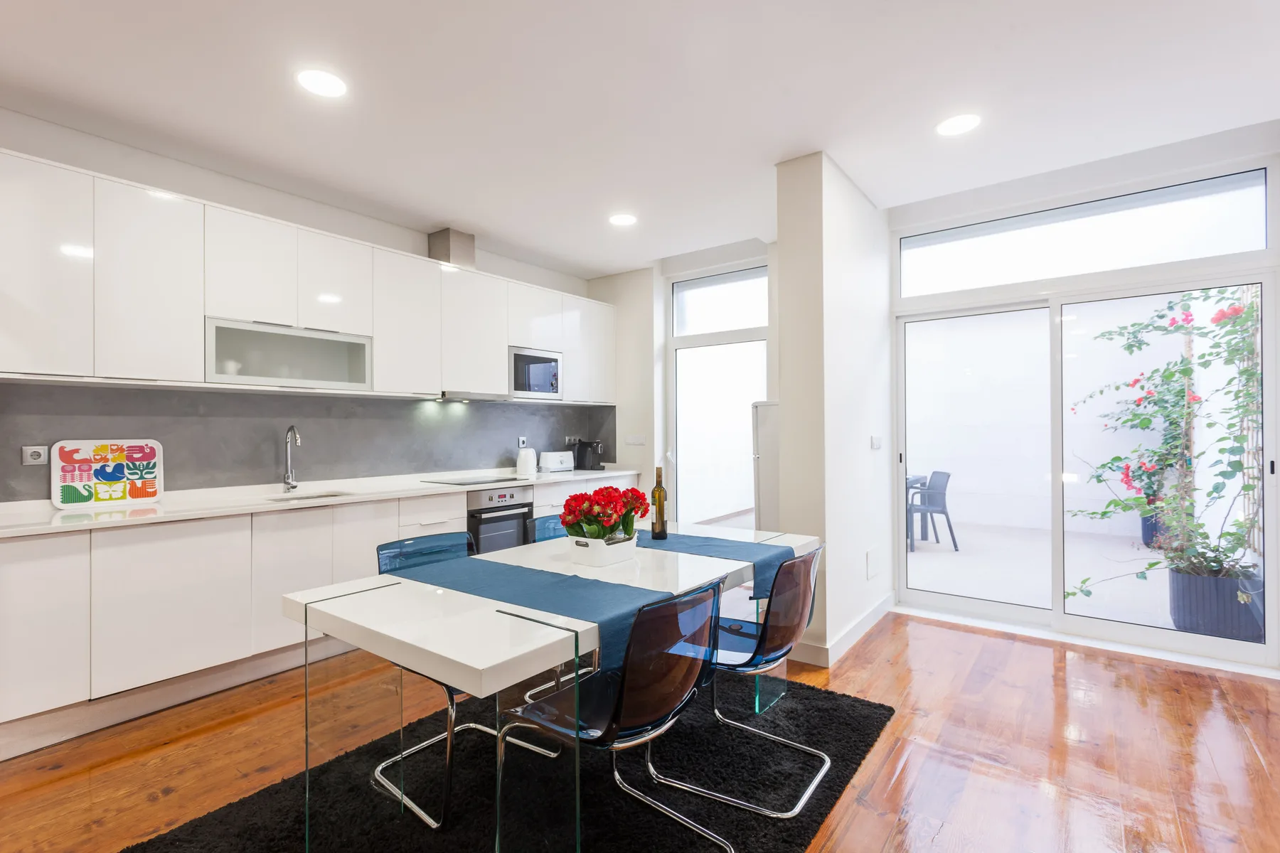 Una cocina luminosa con zona de comedor junto a puertas acristaladas al patio.