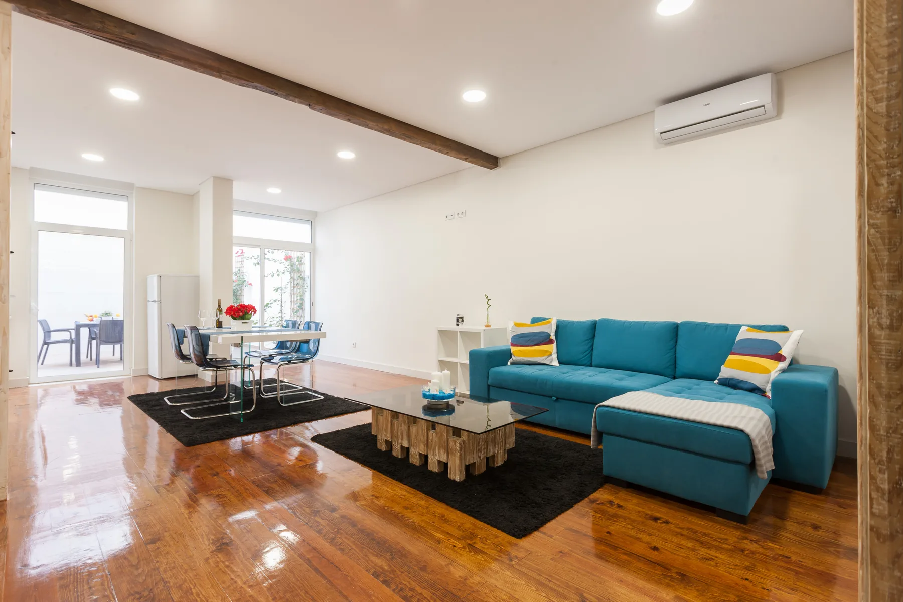 Sala de estar con un sofá seccional azul y un comedor.