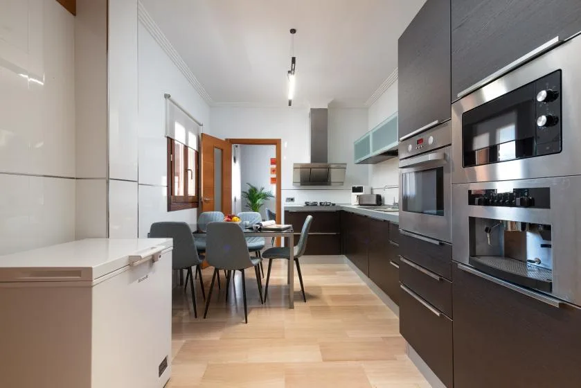 Una cocina moderna con mesa de comedor y electrodomésticos integrados.