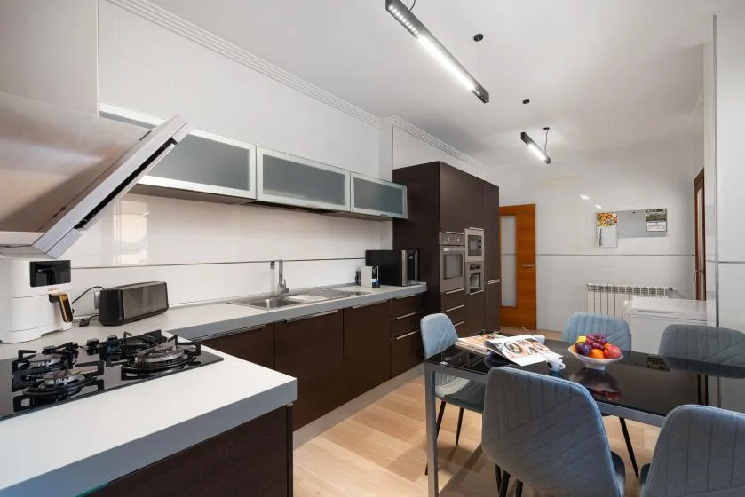 Una cocina moderna con una mesa de comedor y sillas junto a la encimera.