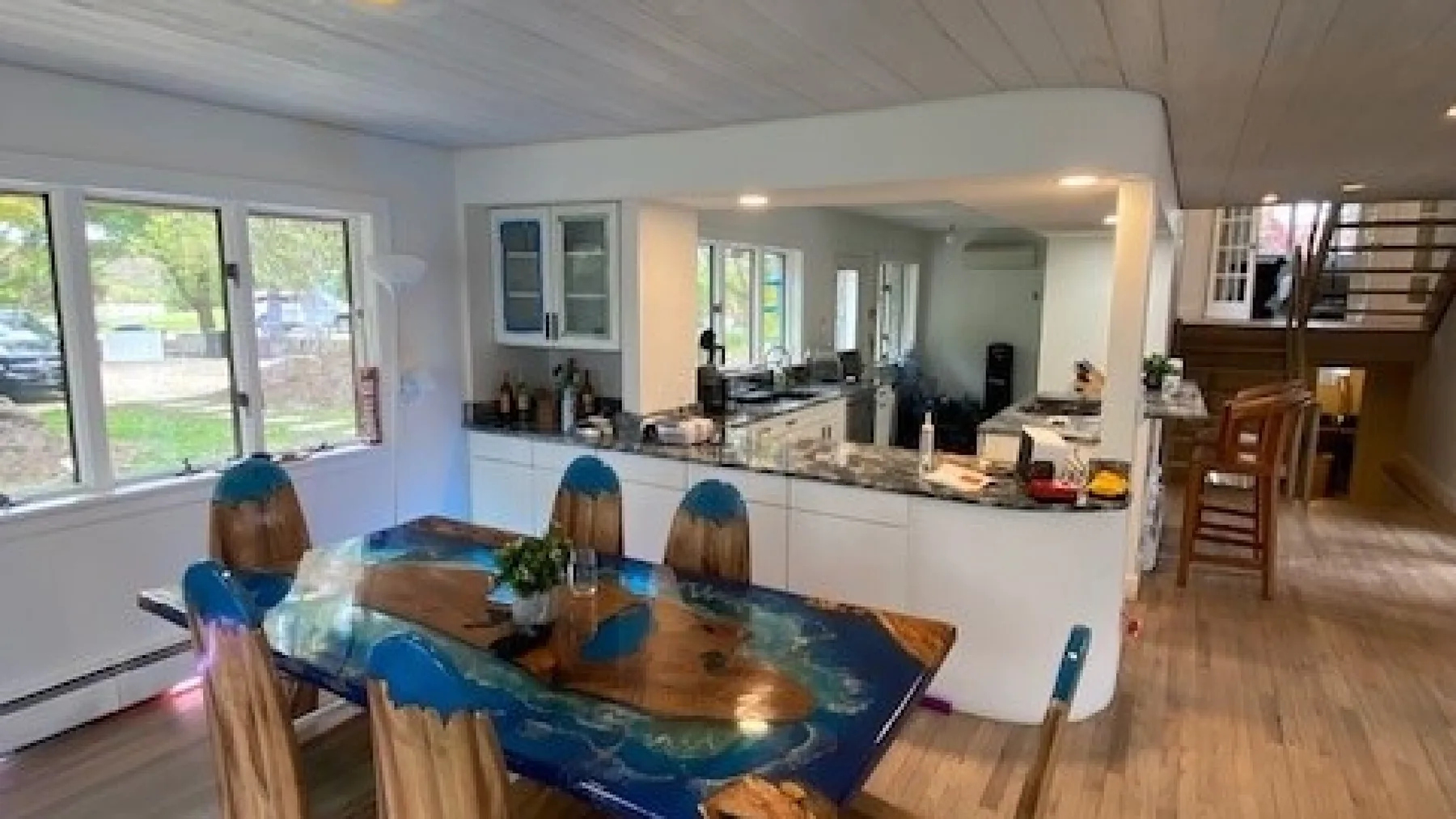 An open-plan kitchen and dining area with a table beside the windows.