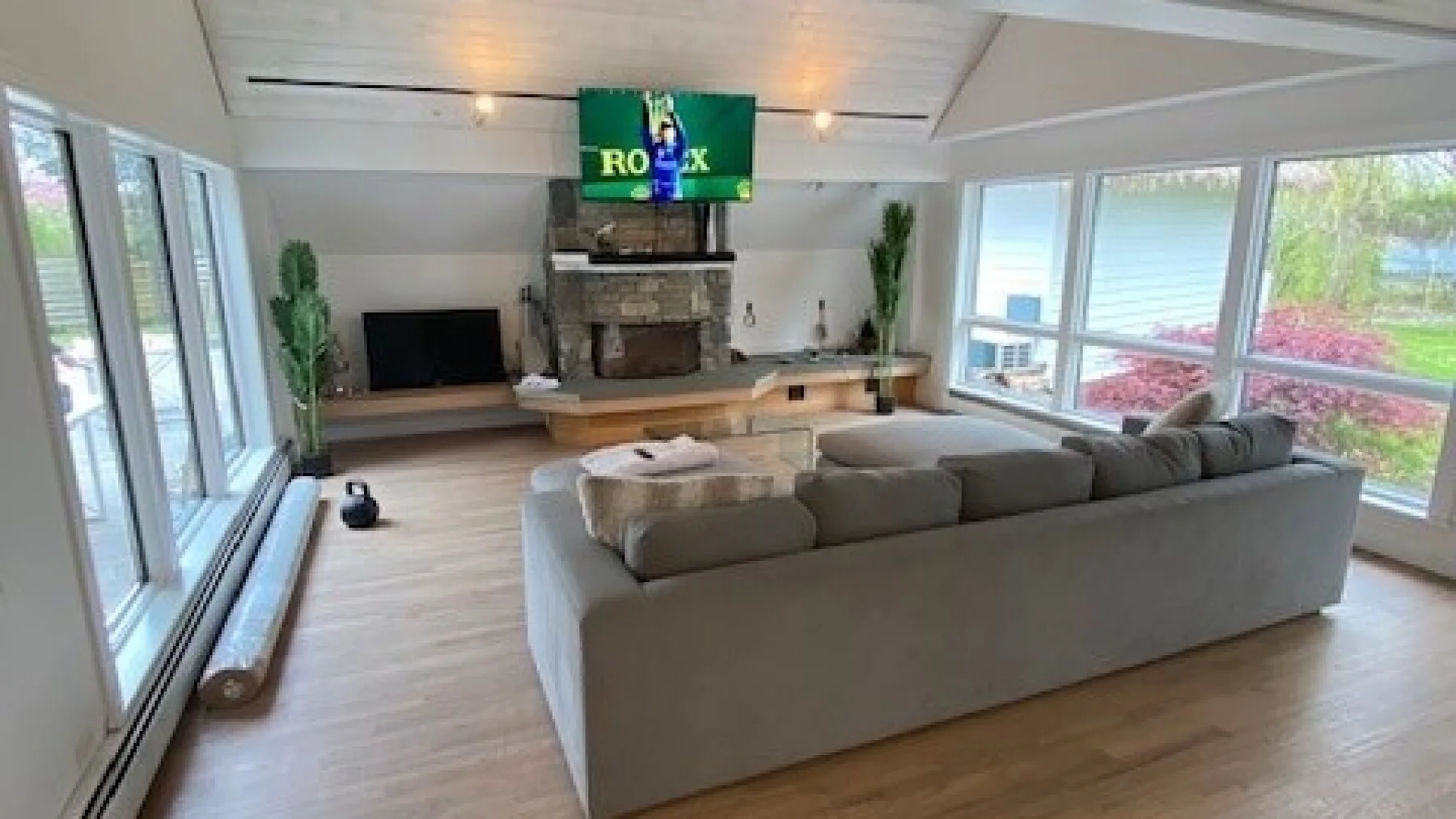 A bright living room with a large sectional sofa facing a fireplace and television.