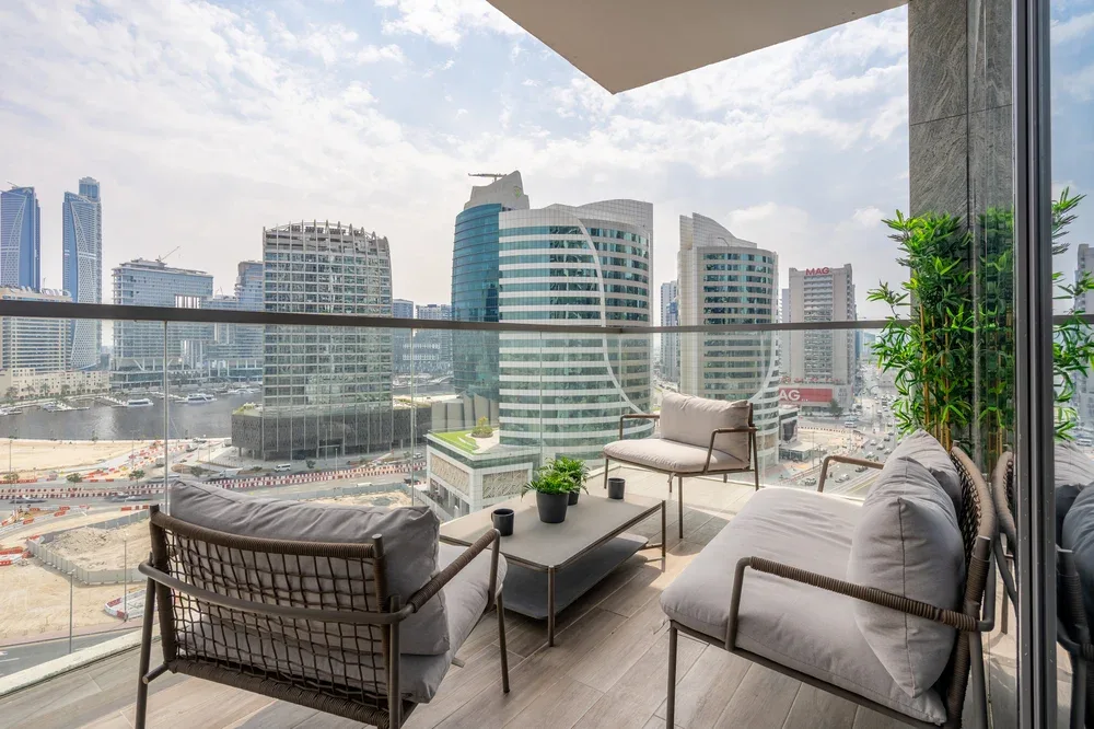 A balcony seating area overlooks a city skyline.