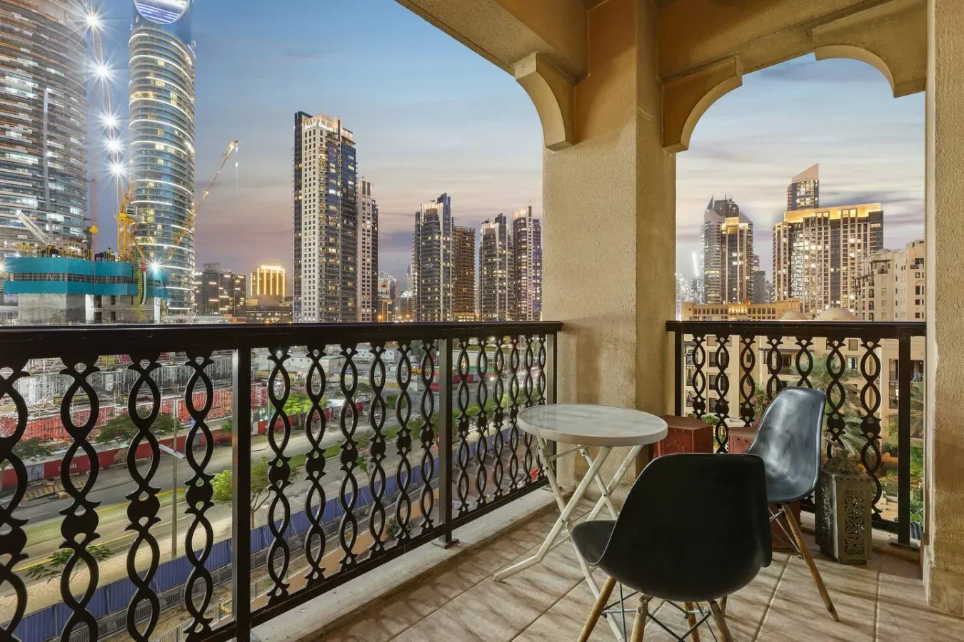 Un balcón da a un horizonte urbano, con asientos junto a la barandilla.