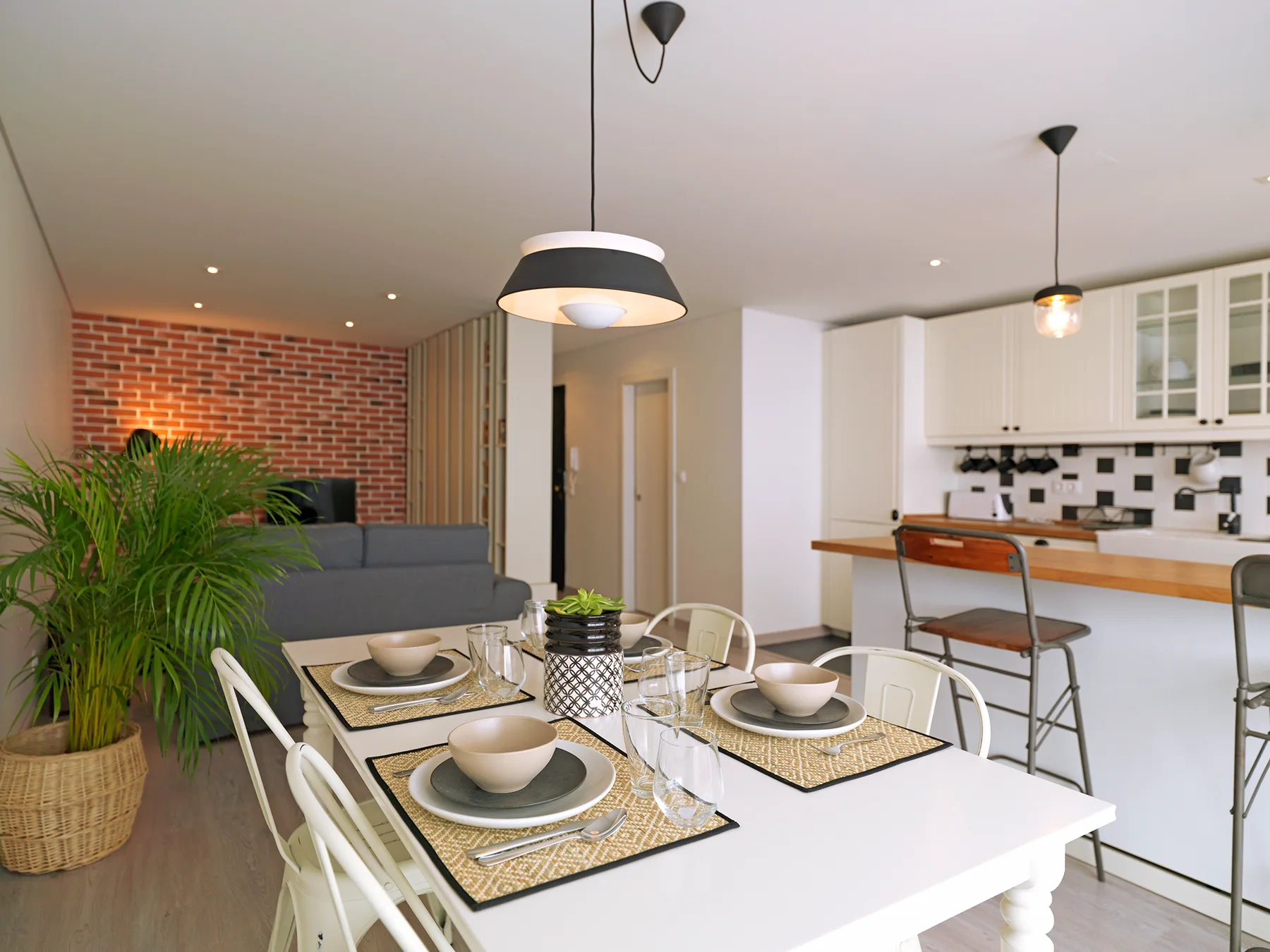 An open-plan living and dining area with a kitchen in the background.