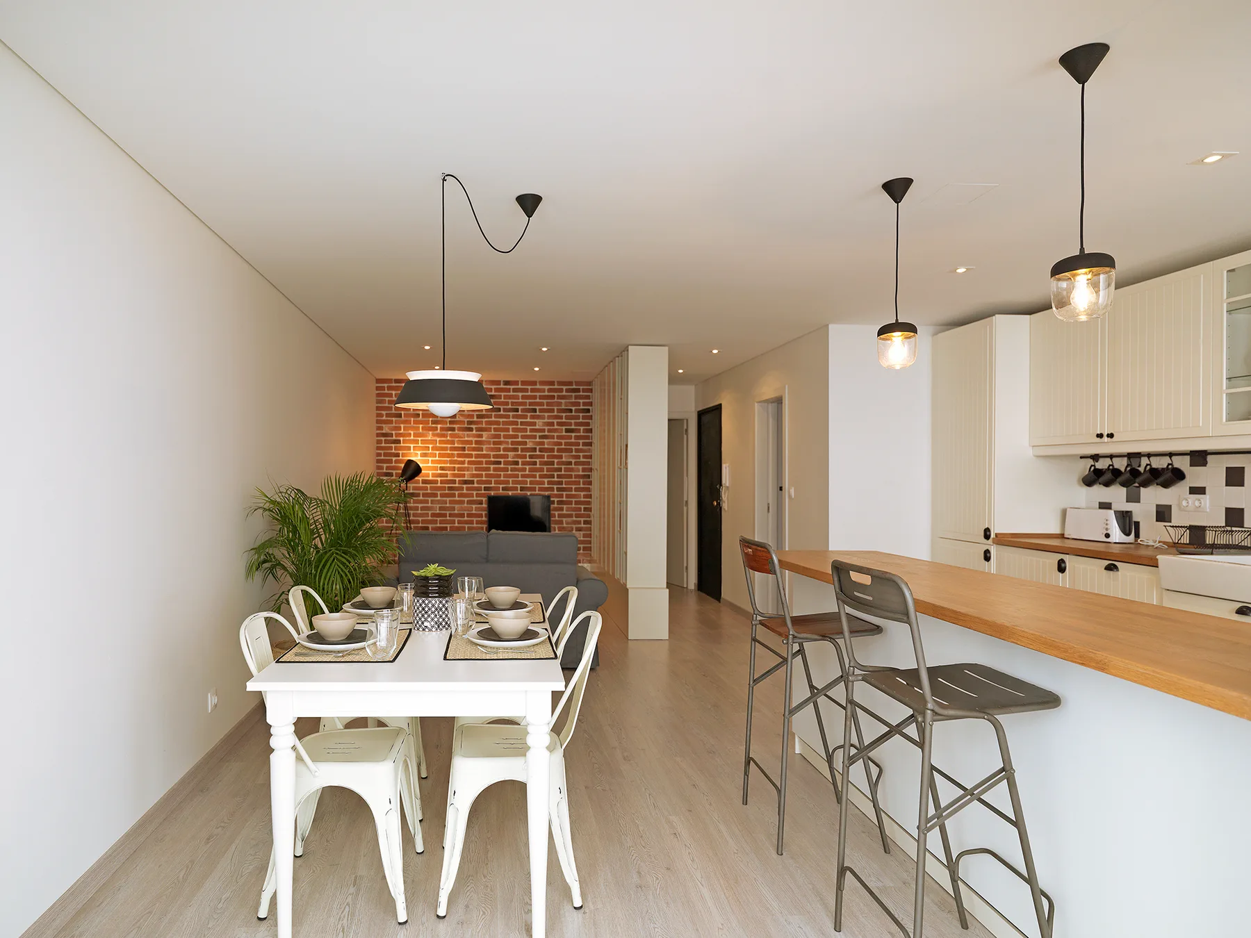 An open-plan dining and kitchen area with a table and breakfast counter.