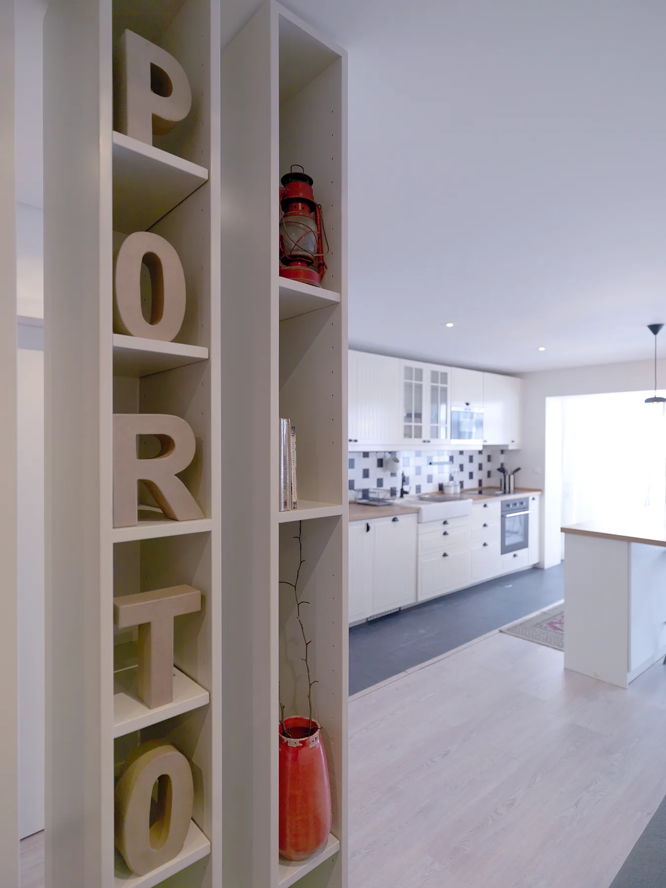 A bright kitchen with white cabinets, a tiled backsplash, and an island.