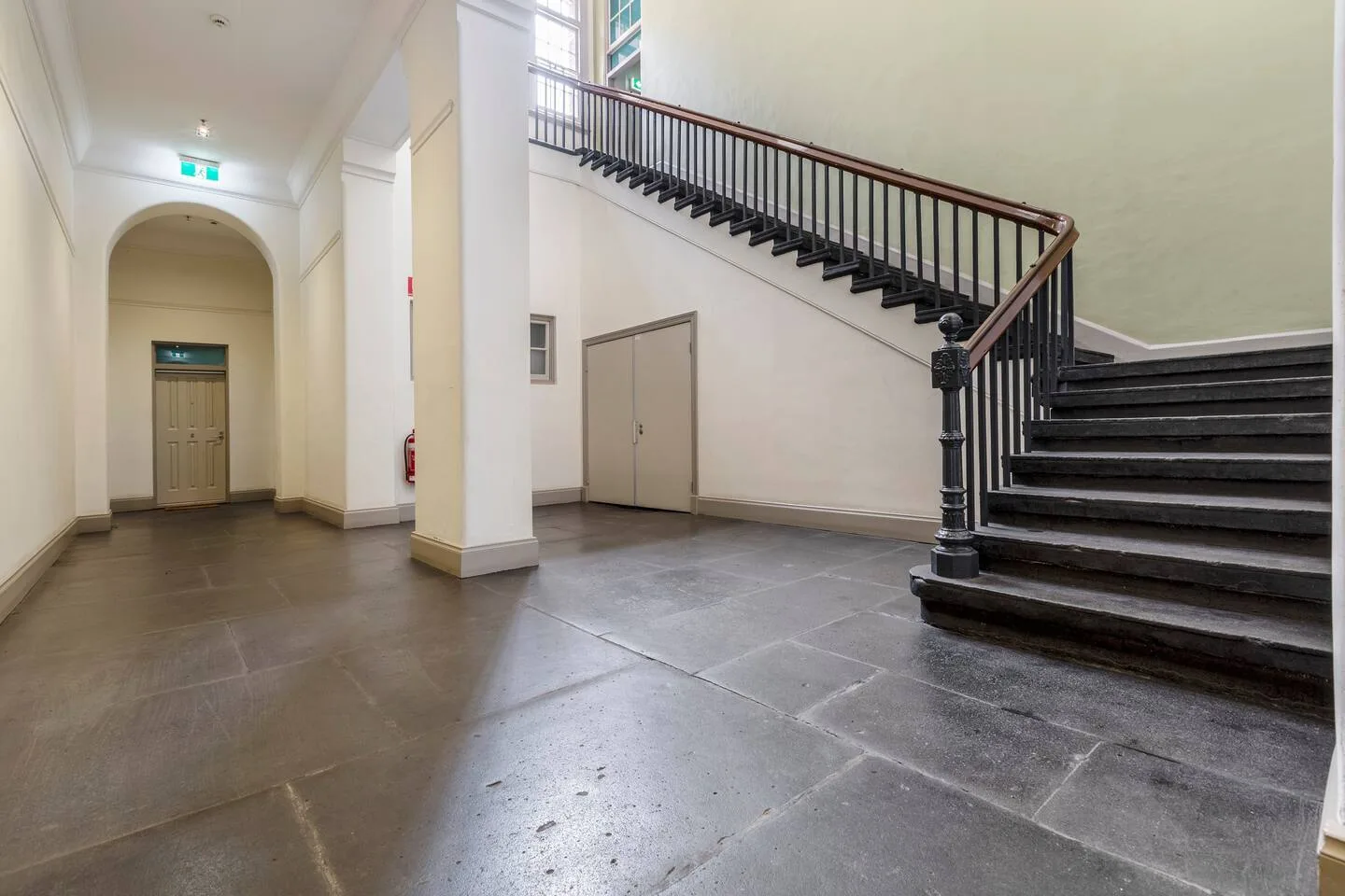A spacious foyer with a staircase and tiled flooring.