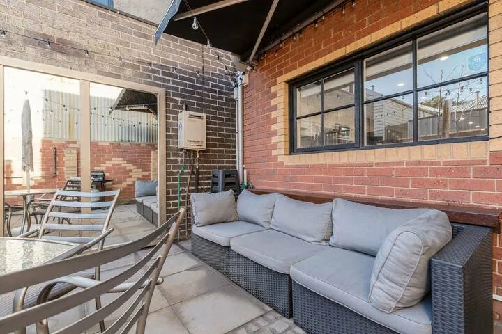 An outdoor seating area with a cushioned sofa and patio table.