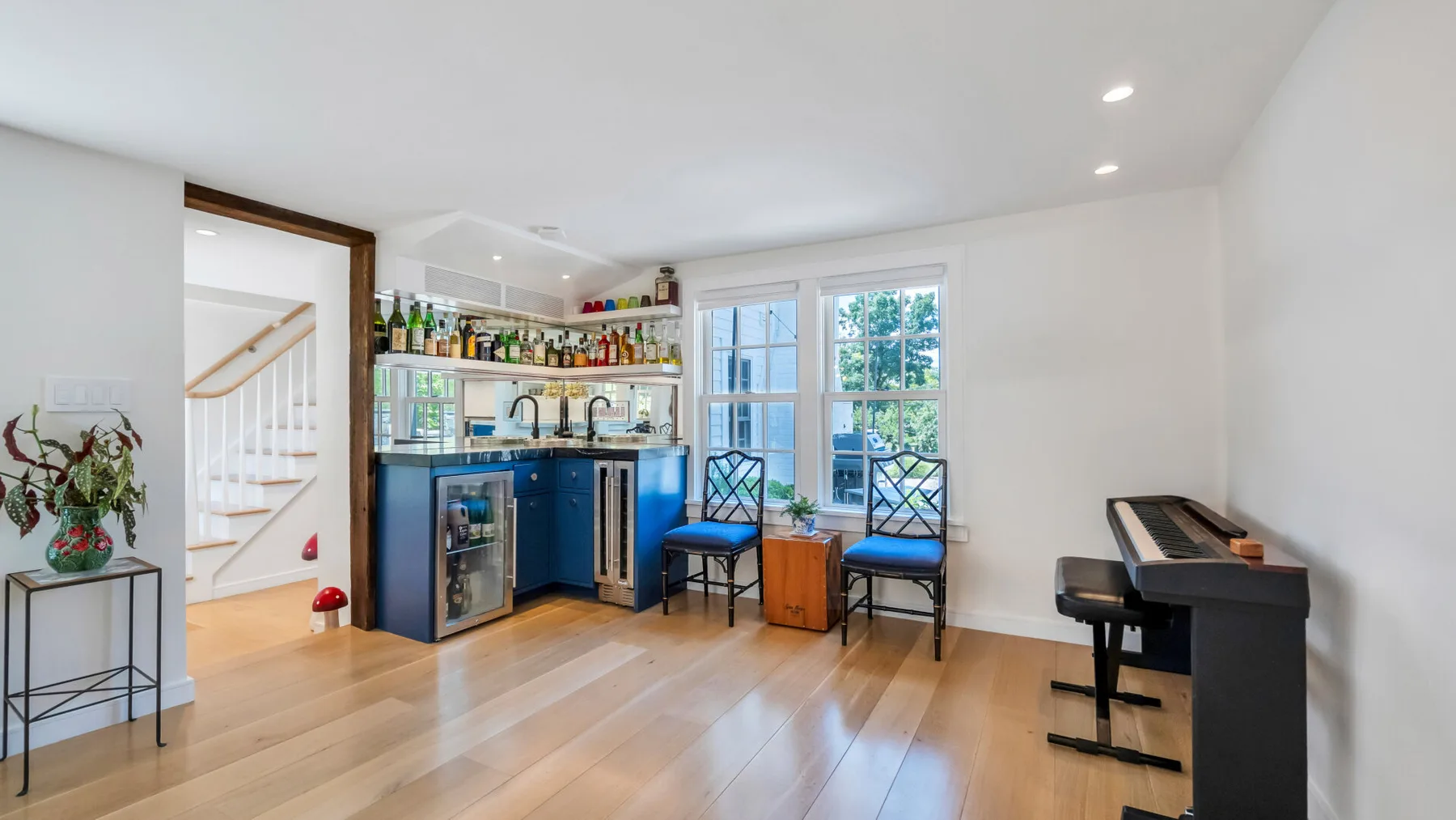 A bright kitchen and dining area with blue cabinetry and a digital piano.