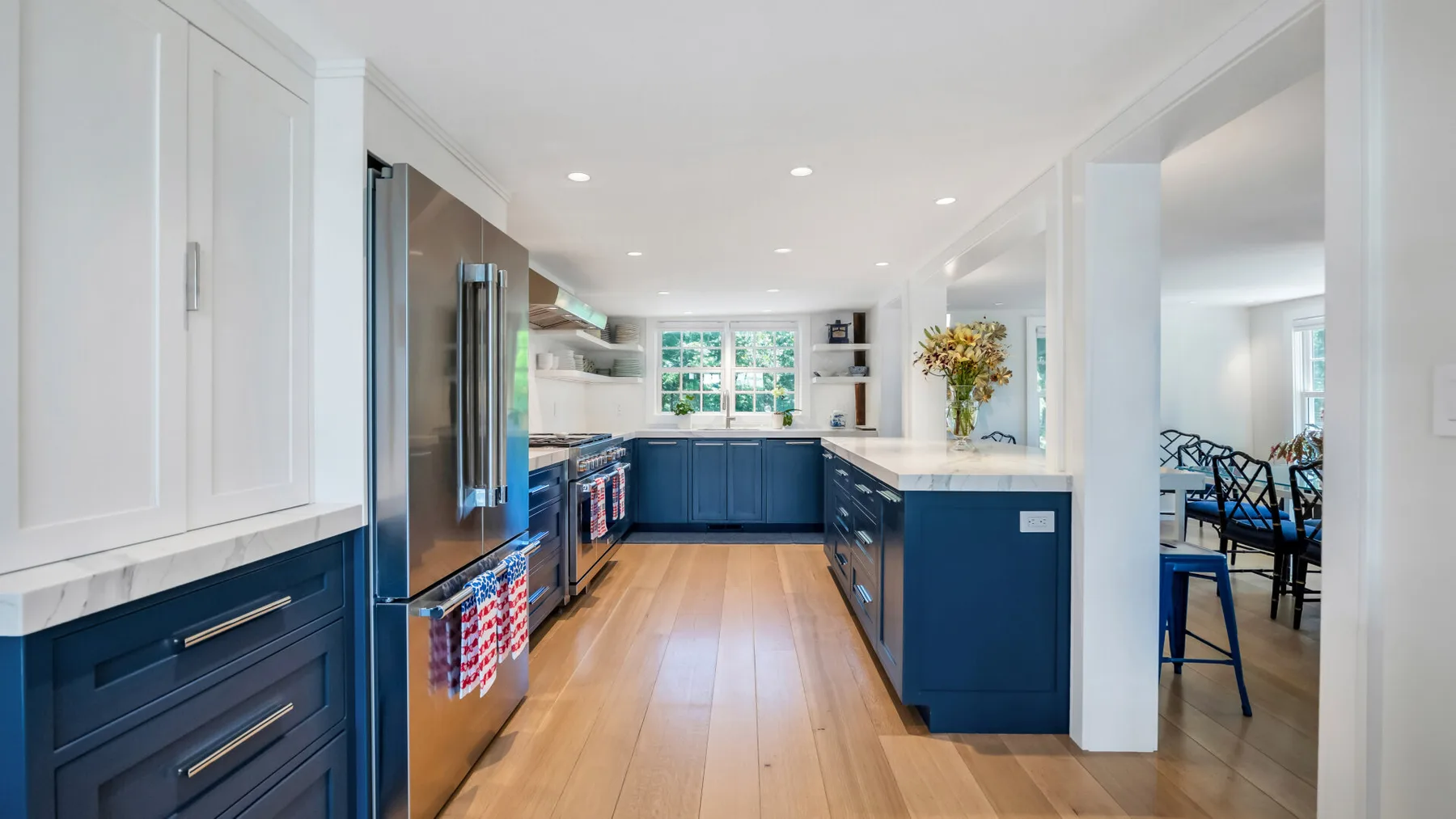 A bright kitchen with dark blue cabinets and a central island.