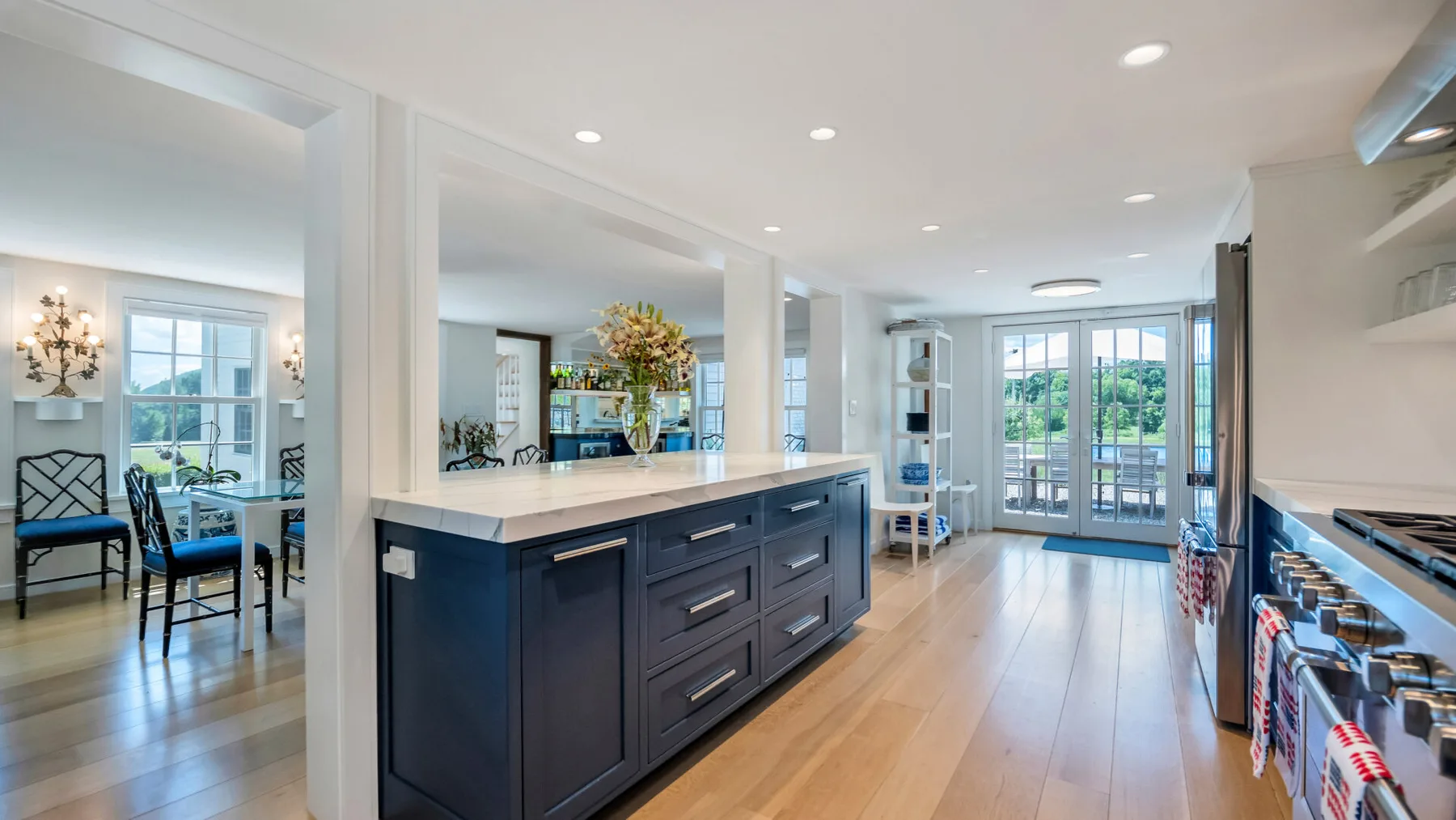 A bright kitchen with a large island and glass doors opening to a patio.