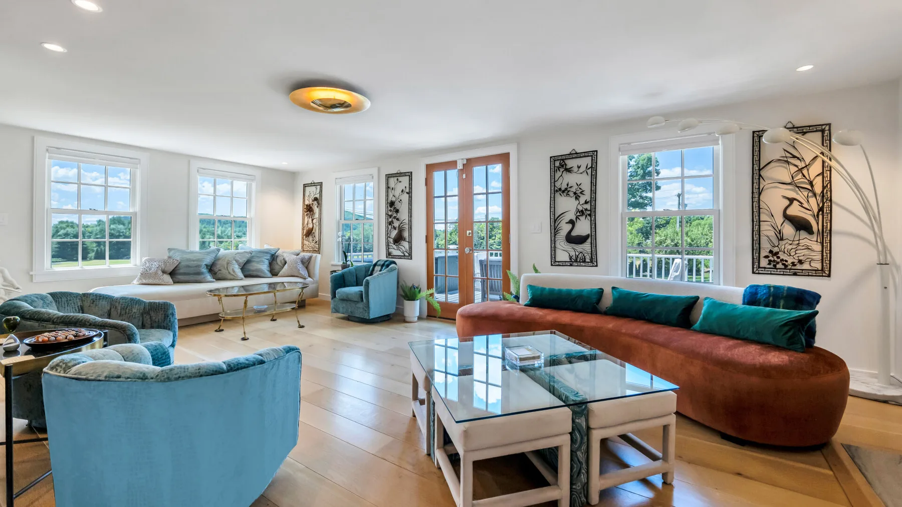 A bright living room with blue seating and a glass coffee table.