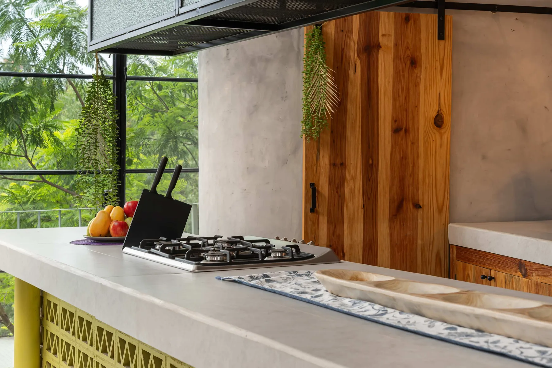 A kitchen counter with a gas cooktop and a wooden door behind it.