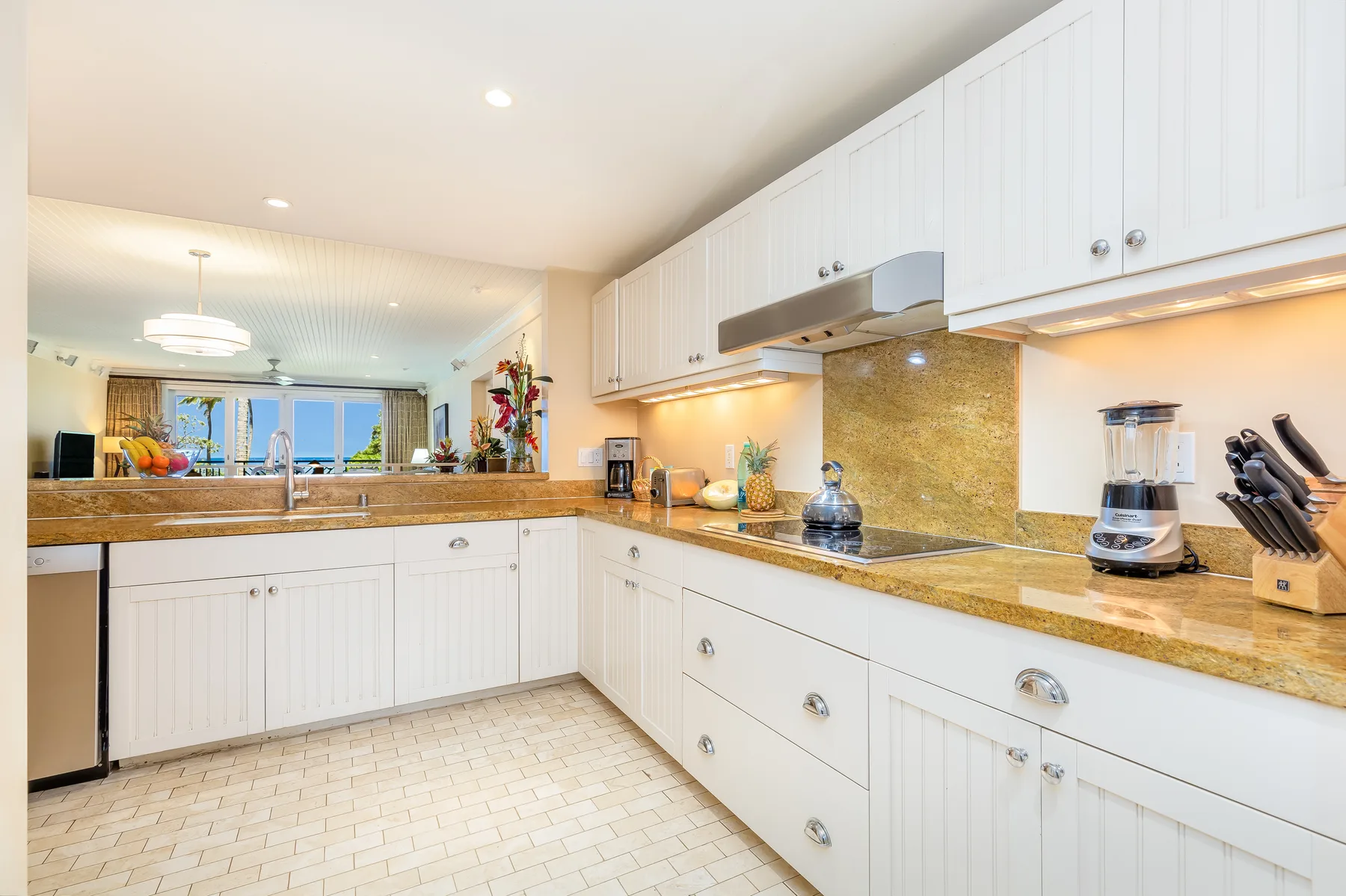 Una cocina luminosa con gabinetes blancos, encimeras y electrodomésticos.