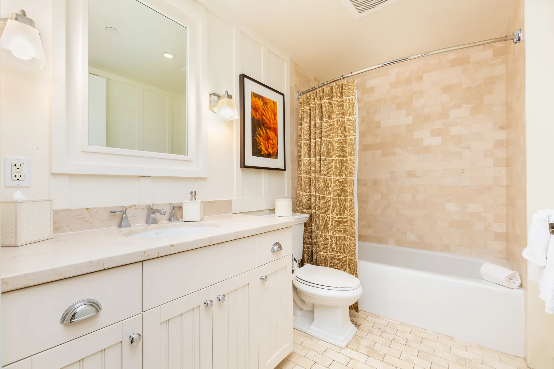 Un baño luminoso con un lavabo largo, espejo, inodoro y bañera con cortina de ducha.