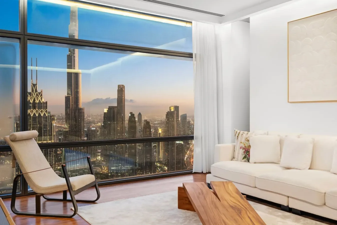A bright living room with floor-to-ceiling windows overlooking a city skyline.