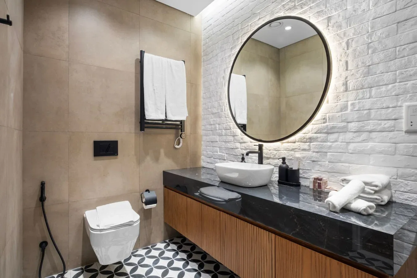 A bathroom with a round mirror above a dark vanity.