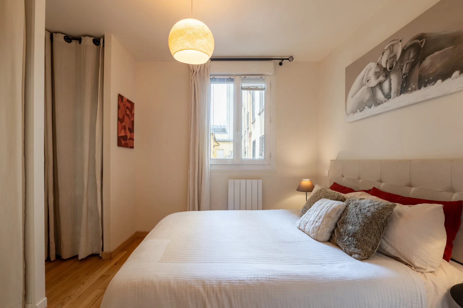 Un dormitorio con una cama bien hecha y una ventana.