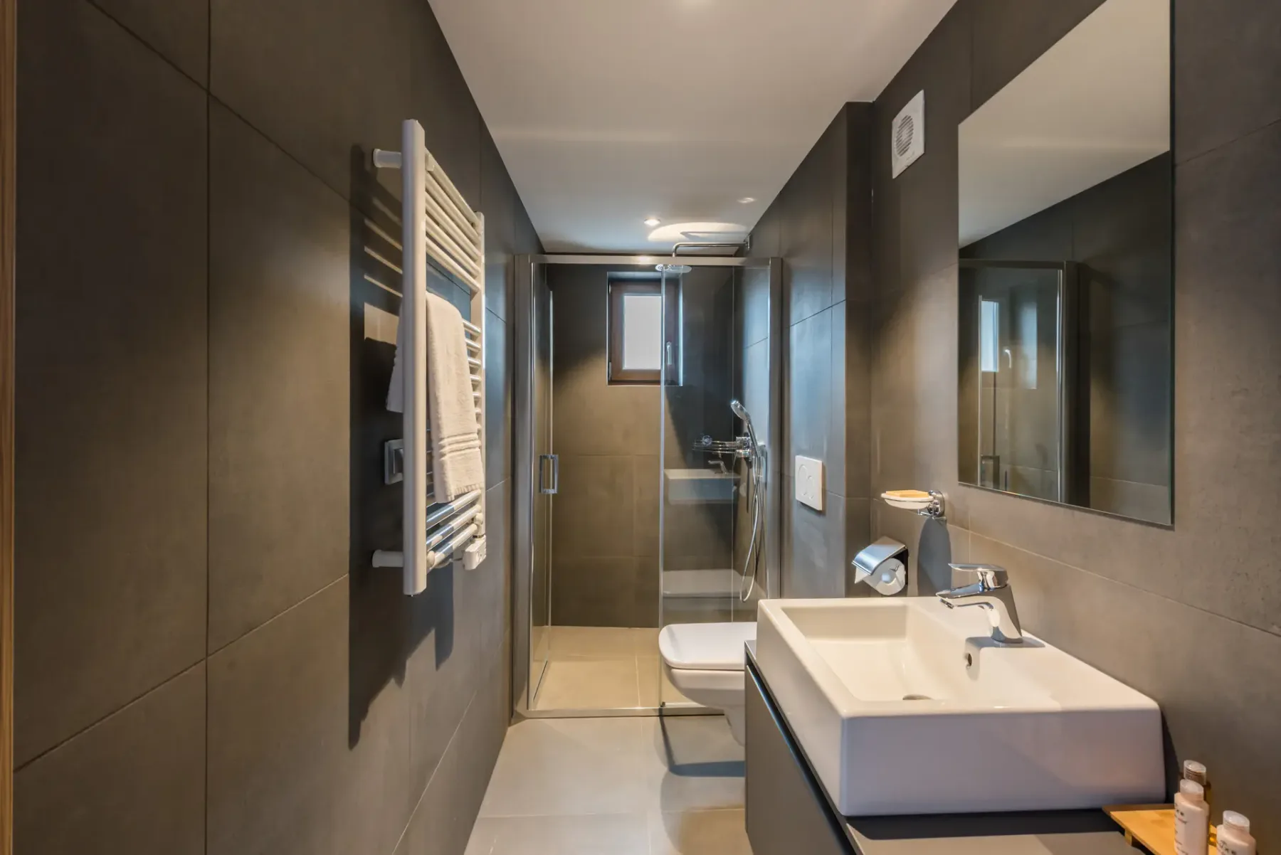 A modern bathroom with a shower and a sink beneath a large mirror.