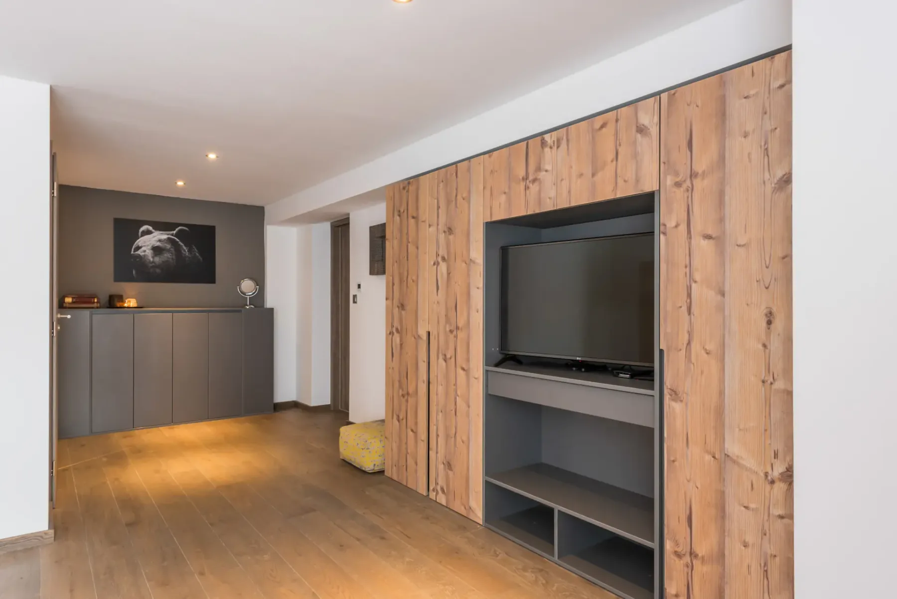 A living area with wood-paneled cabinetry and a television.
