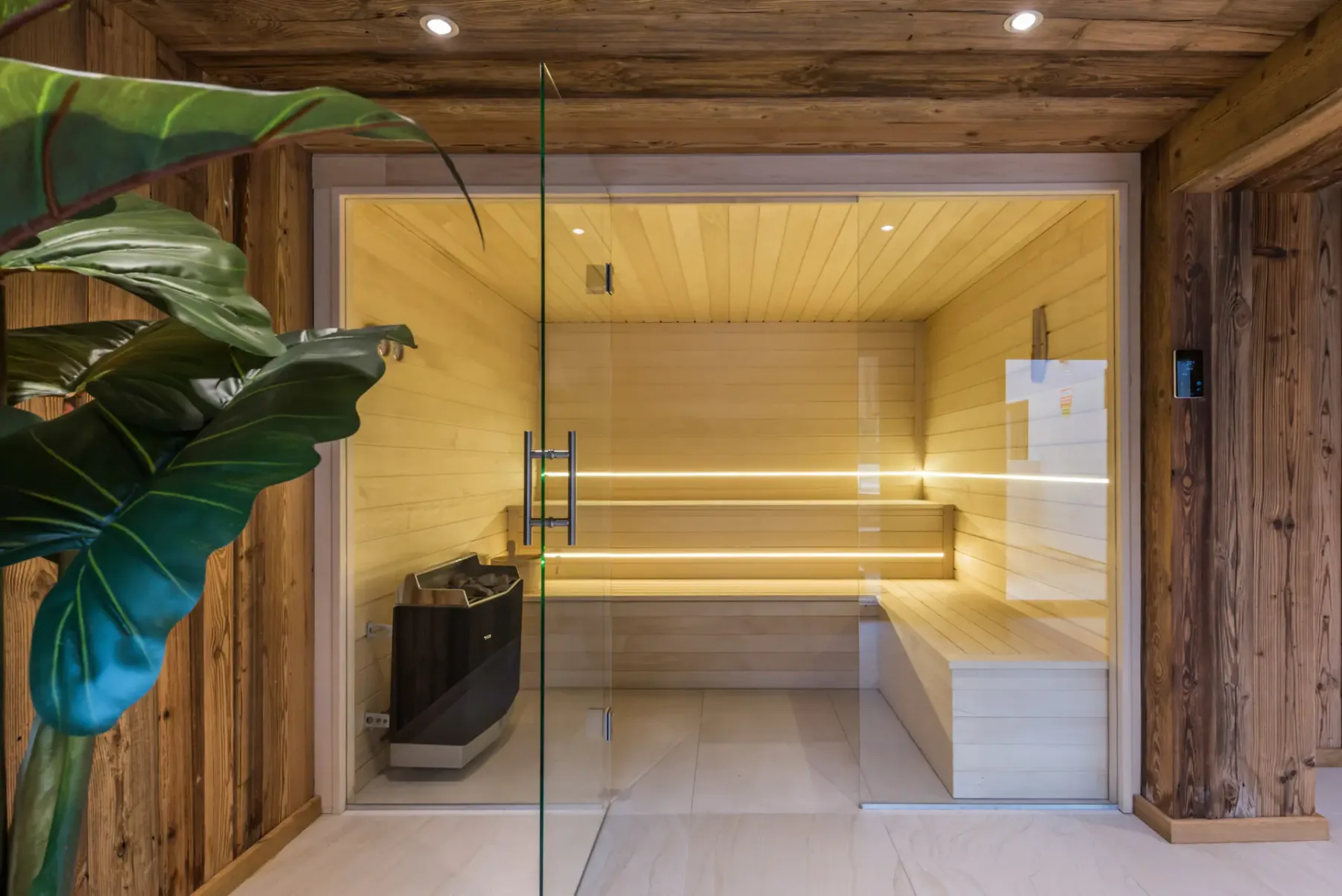 A wooden sauna with tiered seating and a heater.