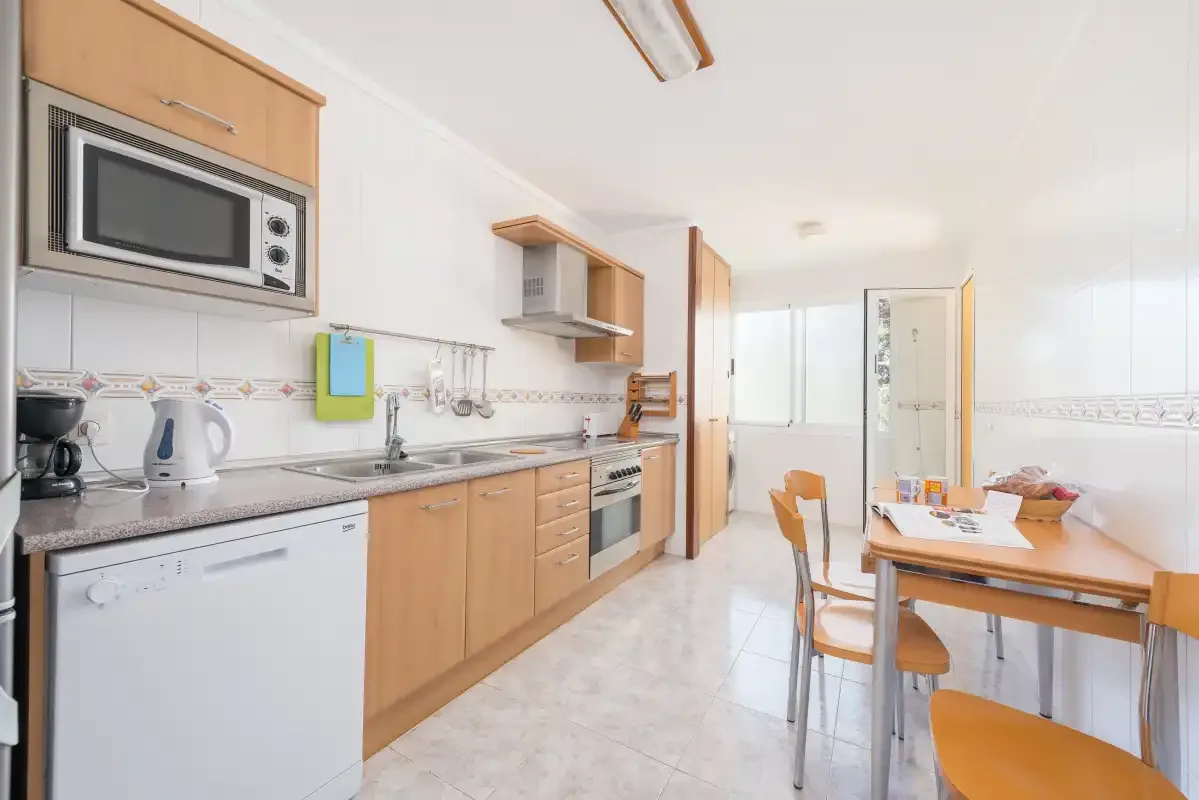 A bright kitchen and dining area with wood cabinets and a table.
