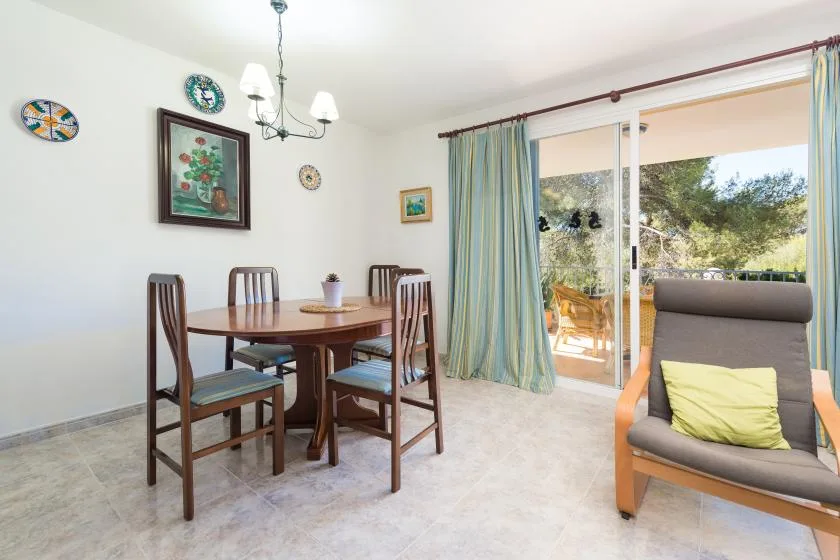 A dining area with a table and chairs beside sliding glass doors.
