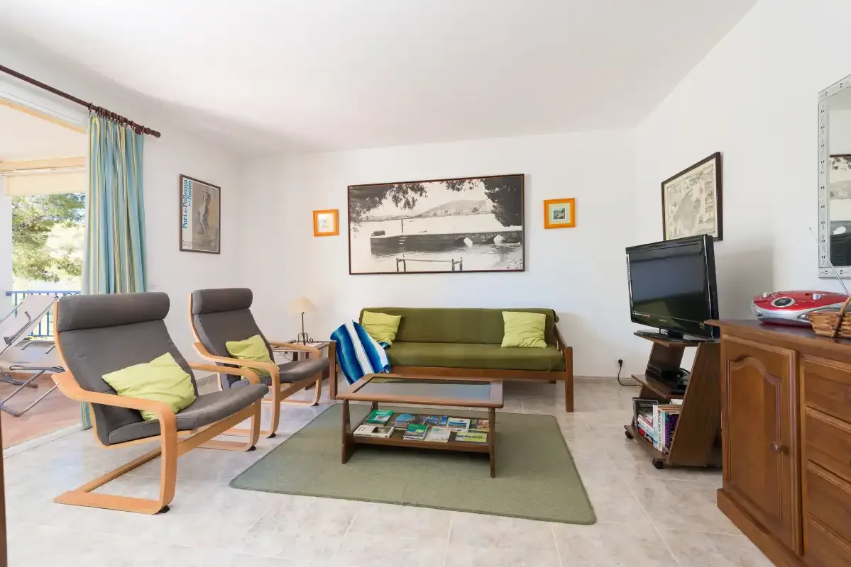 A living room with seating arranged around a coffee table and television.