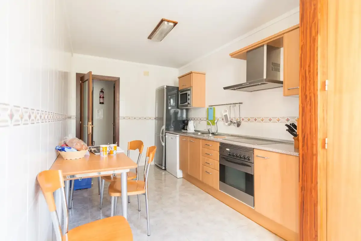 A bright kitchen with a dining table and chairs beside the counter.