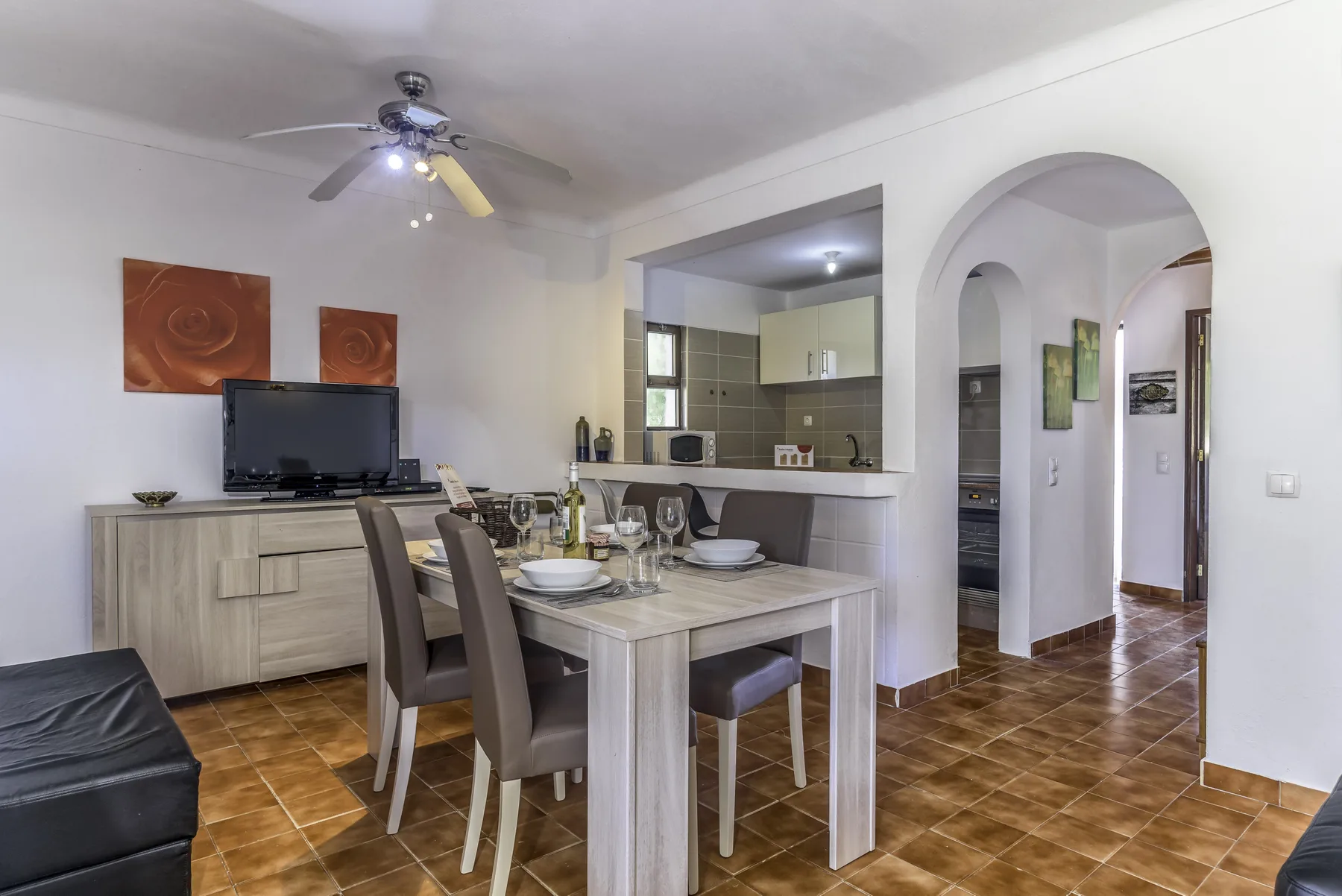 Comedor con mesa y asientos junto a una cocina abierta.