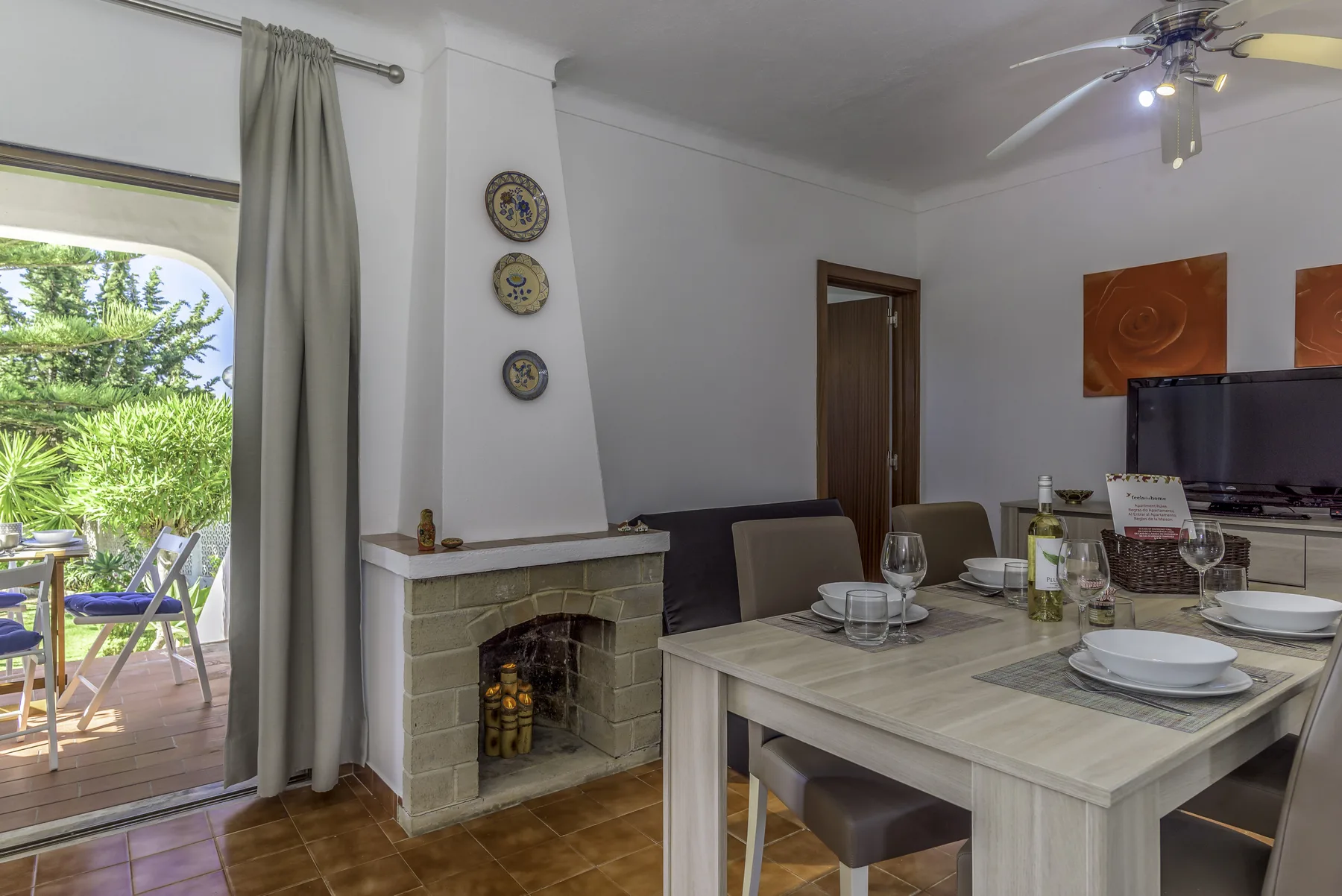 Comedor con chimenea y puertas corredizas de vidrio que dan a un patio.
