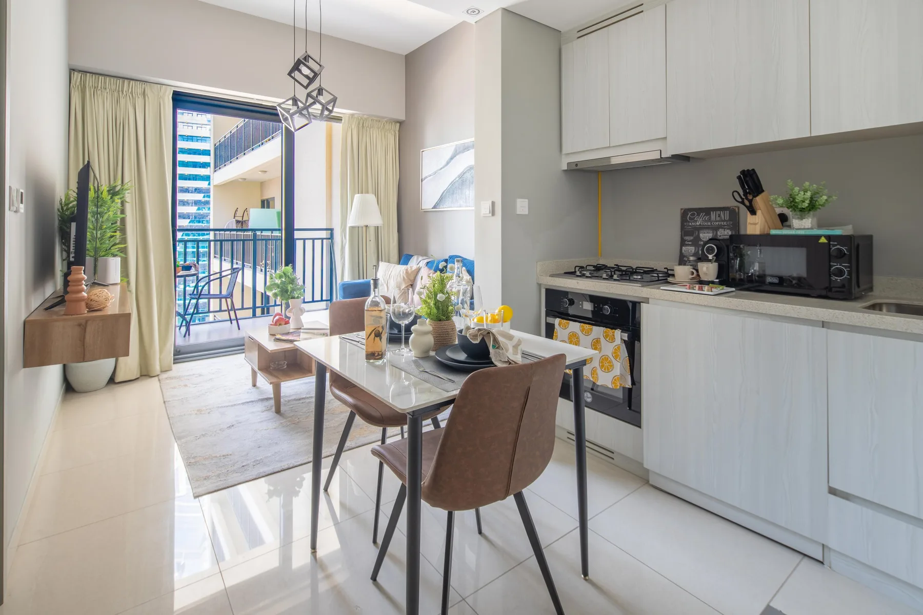 Una luminosa cocina-comedor abierta con una mesa junto a un balcón.