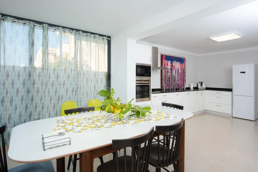 Comedor con una mesa junto a una cocina abierta.