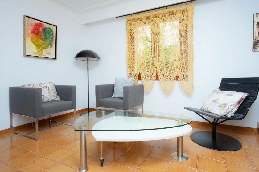 Una sala de estar con asientos alrededor de una mesa de centro de vidrio.