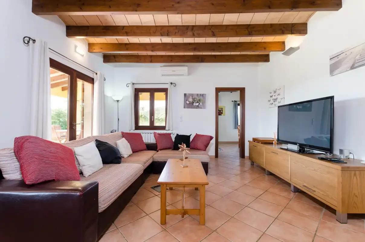 Una sala de estar con asientos, una mesa de centro y un televisor.