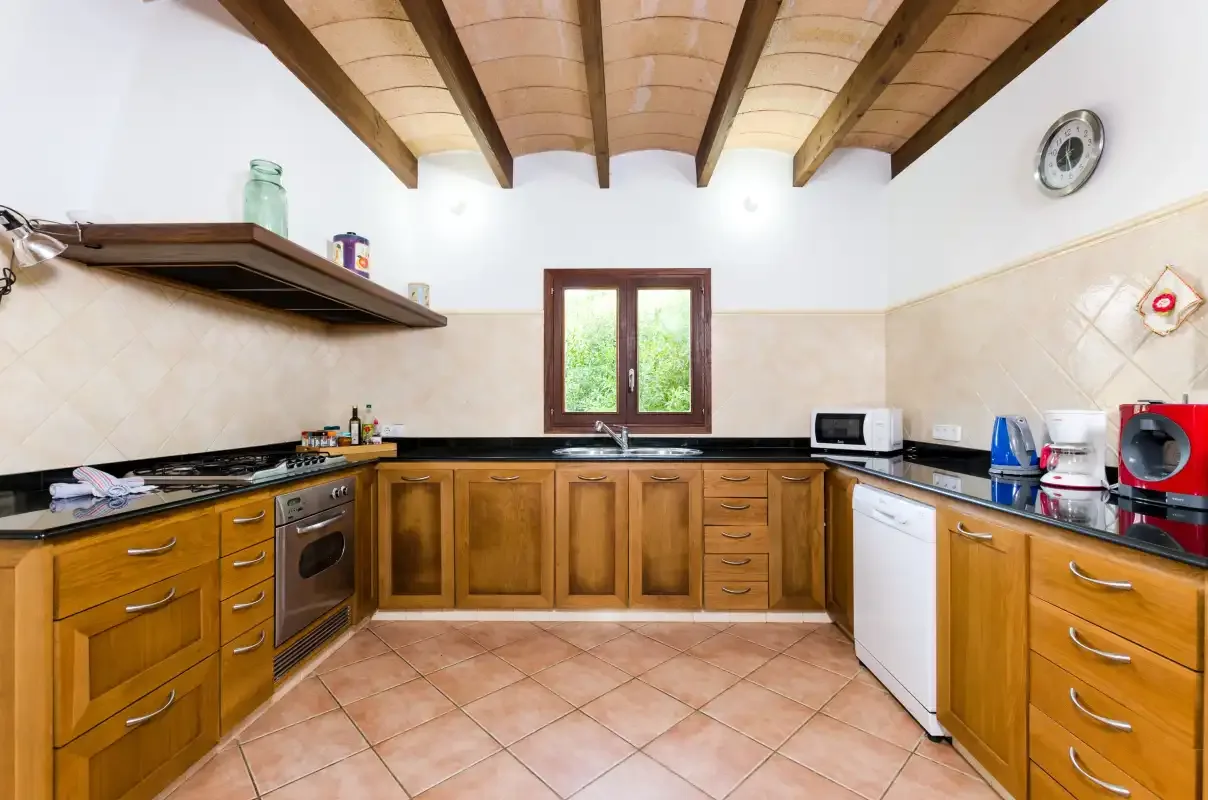 Una cocina con armarios de madera, encimeras y una ventana.