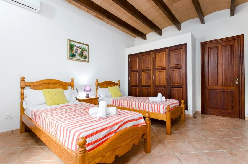 Un dormitorio con dos camas de madera vestidas con ropa de cama a rayas.