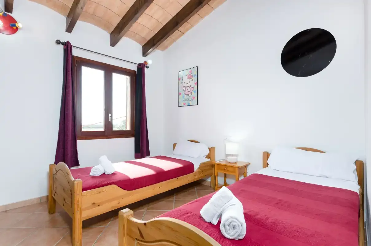 Un dormitorio con dos camas vestidas con ropa de cama roja y blanca.