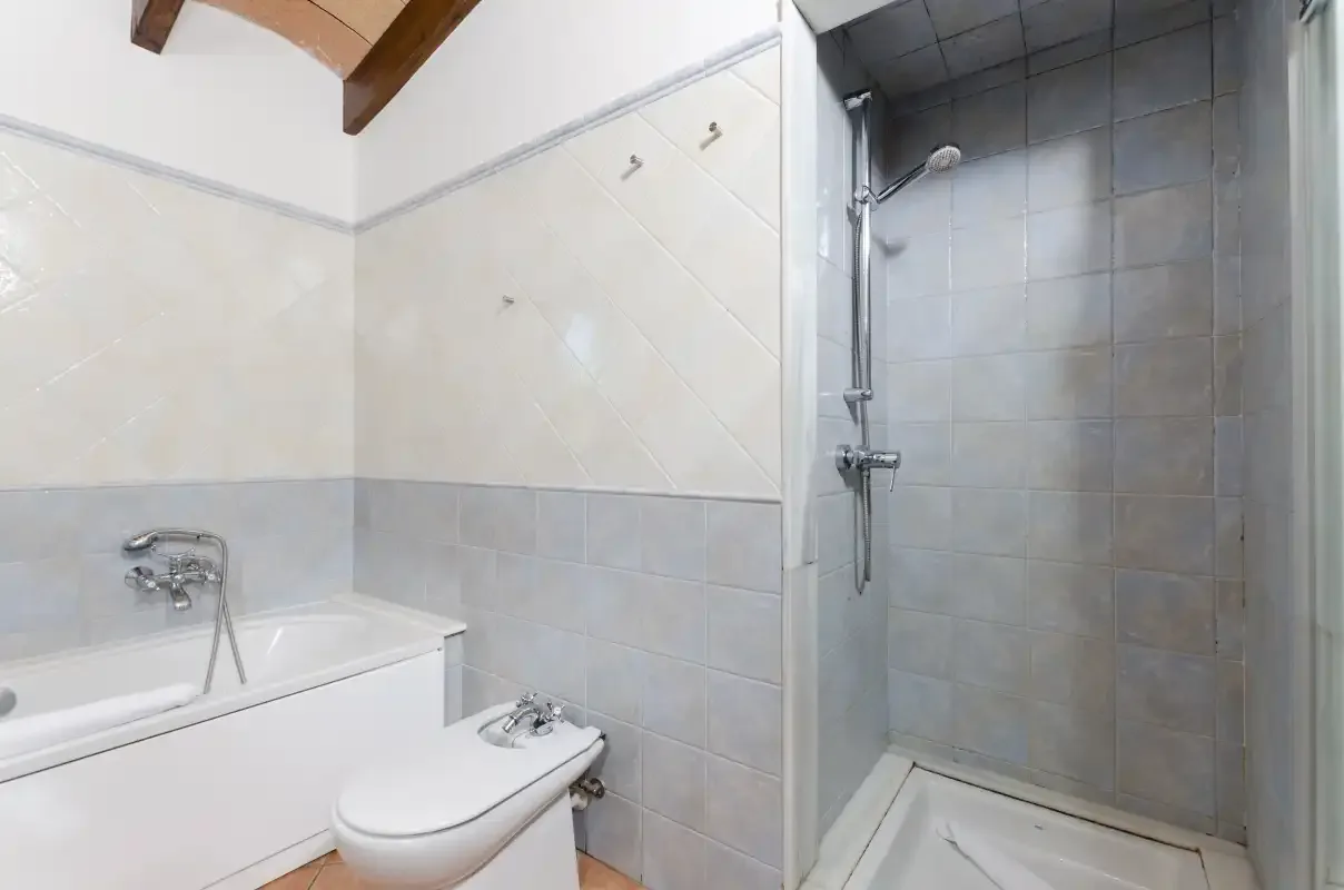 Un baño alicatado con bañera, inodoro y ducha independiente.