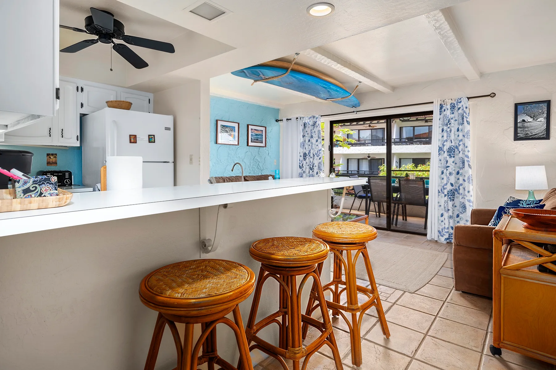 Open-plan kitchen and dining area with a long counter and wooden stools.