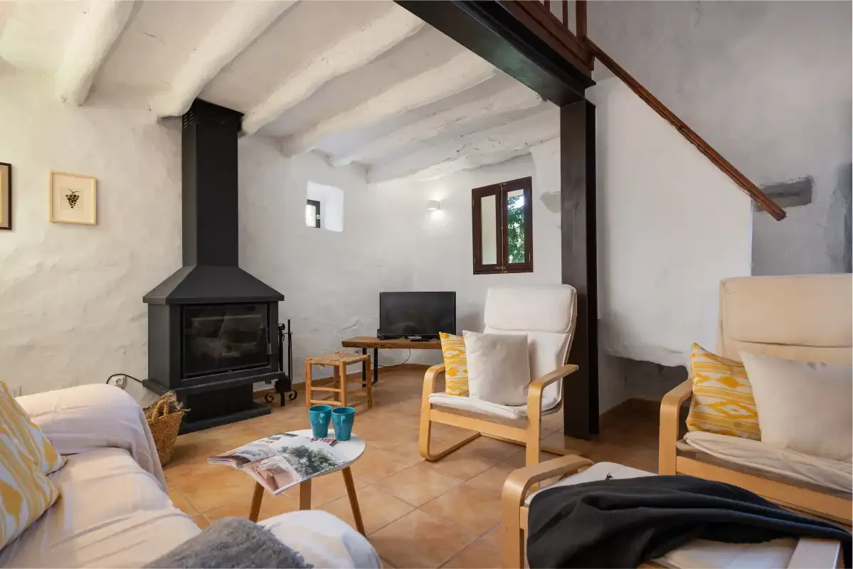 Una sala de estar con chimenea, asientos y un televisor.