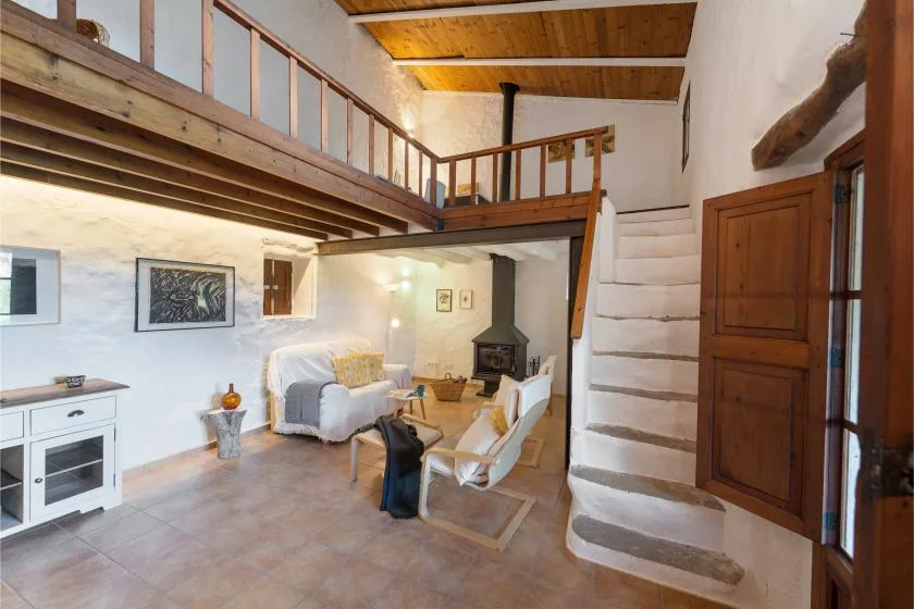 Una sala rústica con un altillo de madera elevado y una zona de estar.