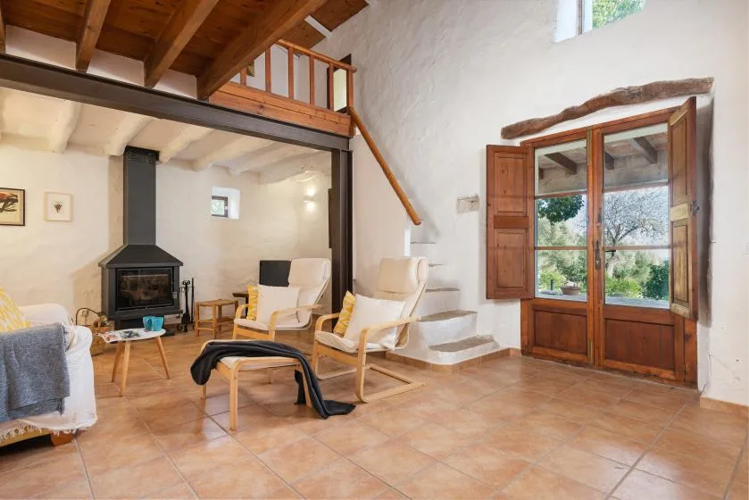 Una sala de estar con asientos, una chimenea y una escalera de madera.