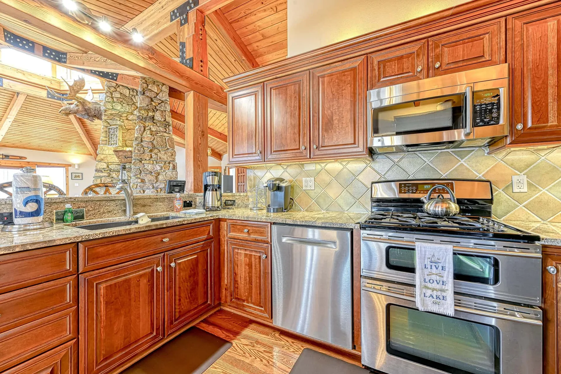 Una cocina con gabinetes de madera, un lavavajillas de acero inoxidable y una estufa.